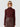 Woman wearing a burgundy top and brown leather skirt on a white background